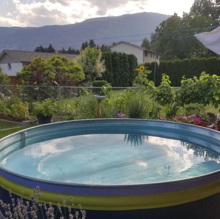 a swimming pool in a yard with a garden at Global Village Permaculture BnB in Oliver