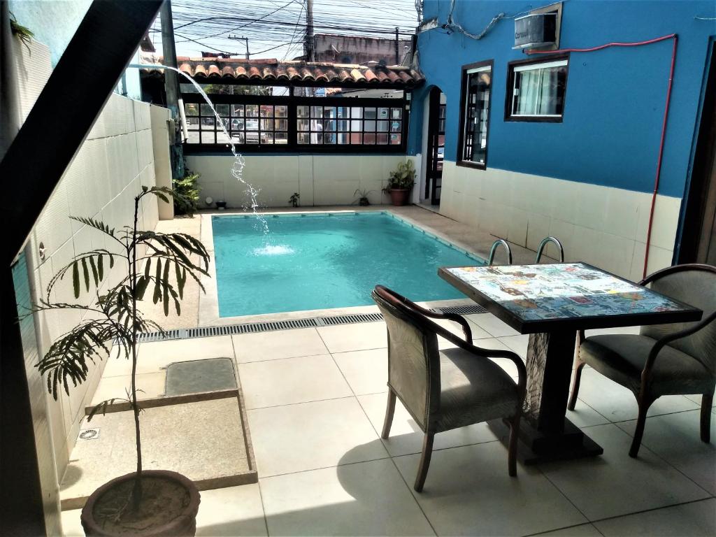 a patio with a table and a swimming pool at Pousada Mandala in Búzios
