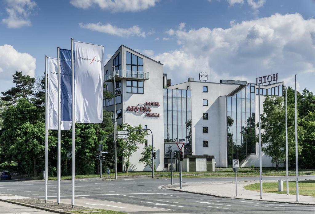 um grande edifício branco com muitas janelas em ARVENA Messe Hotel em Nurembergue