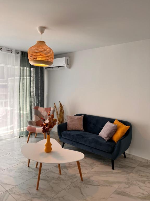 ein Wohnzimmer mit einem blauen Sofa und einem Tisch in der Unterkunft Casa de Tres Hermanos in the heart of Athens in Athen