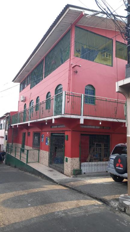 un edificio de color rosa con un balcón en el lateral. en Ótimo apartamento, en Manaus
