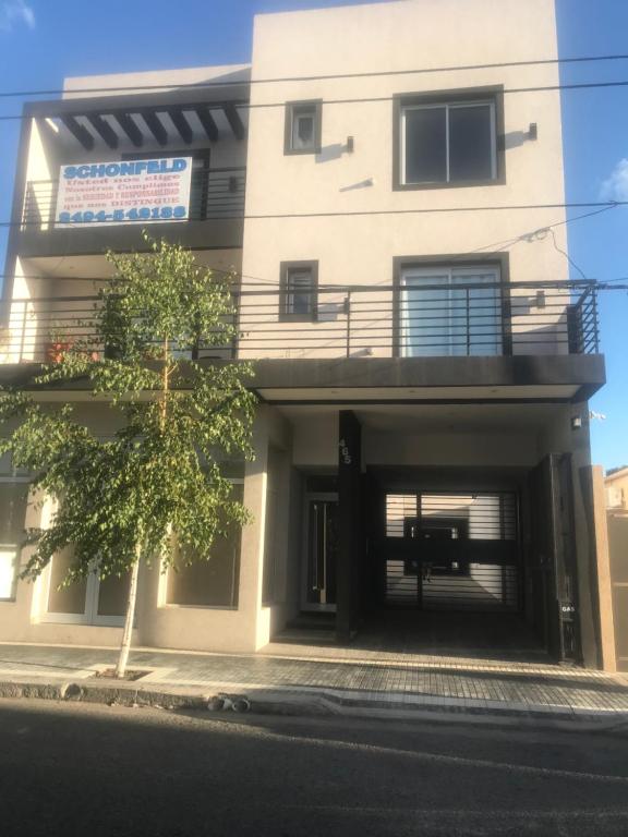 un gran edificio blanco con garaje abierto en departamento tandil centro en Tandil