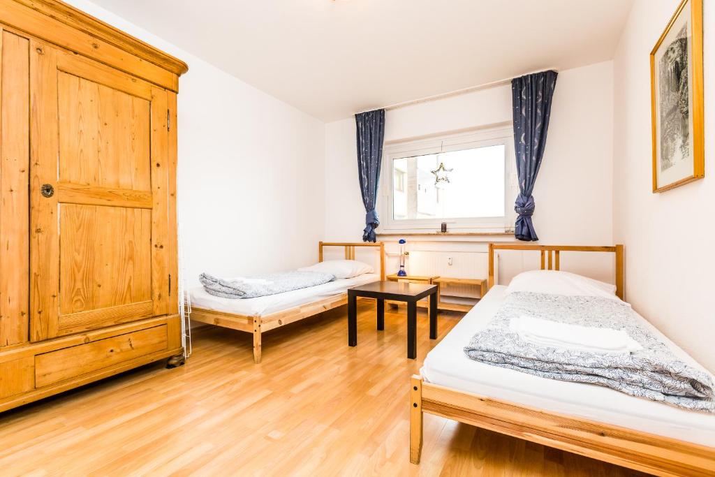 1 dormitorio con 2 camas y armario de madera en Apartment Köln Neubrück, en Colonia