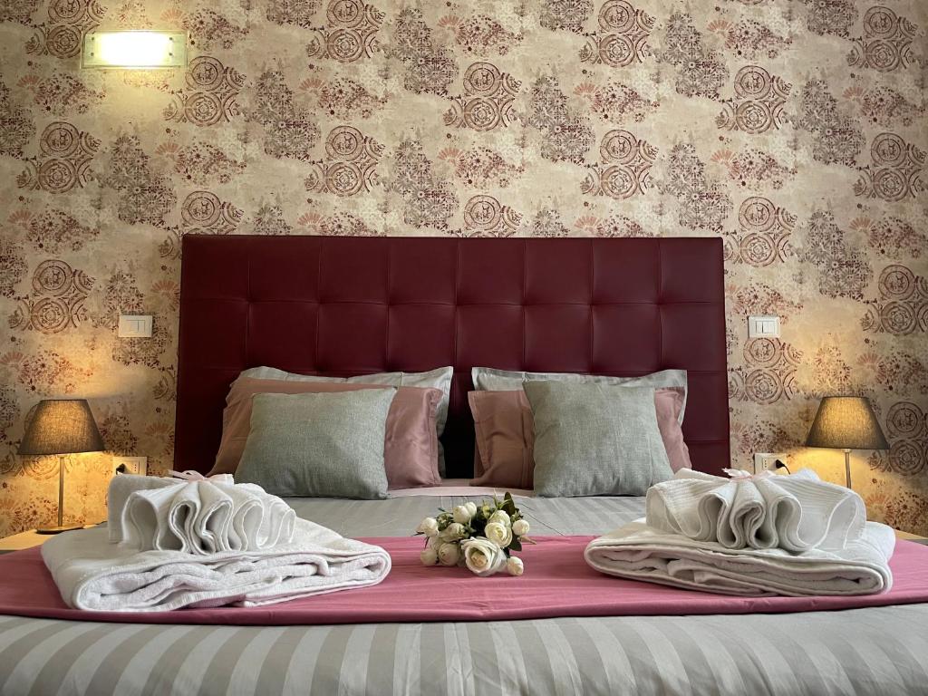 uma cama grande com cobertores brancos e almofadas em Porta alla Croce Guest House em Florença