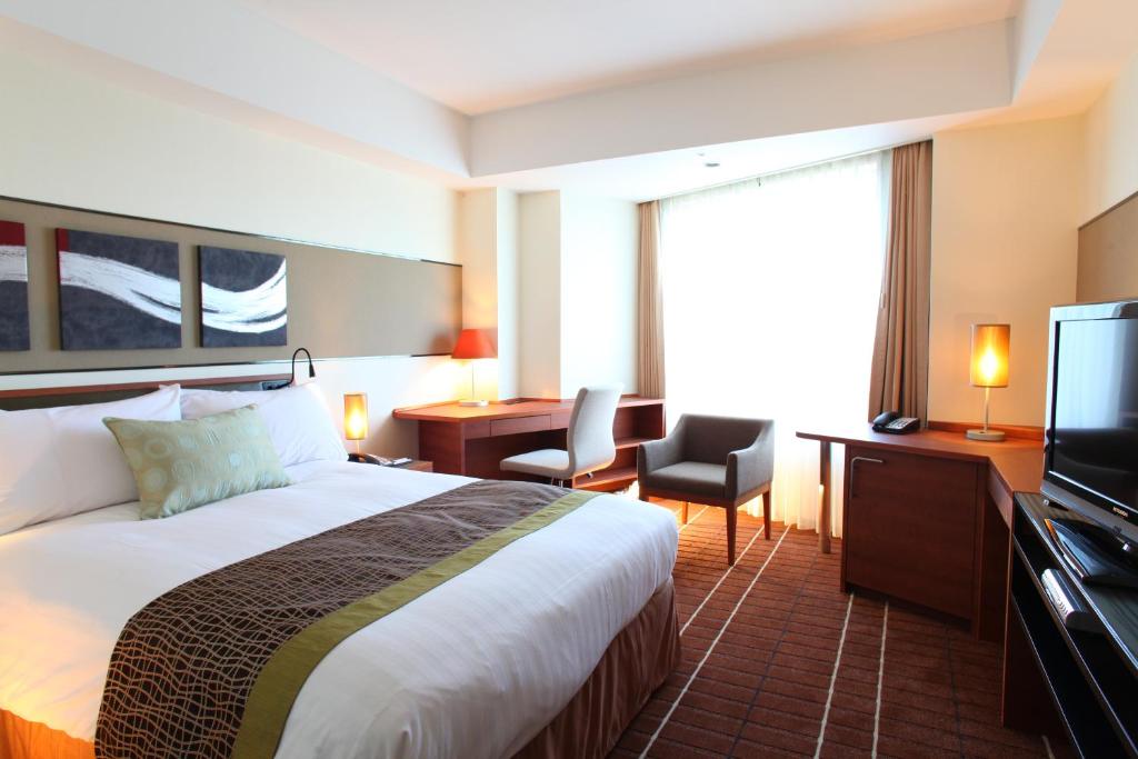 a hotel room with a bed and a television at International Resort Hotel Yurakujo in Narita