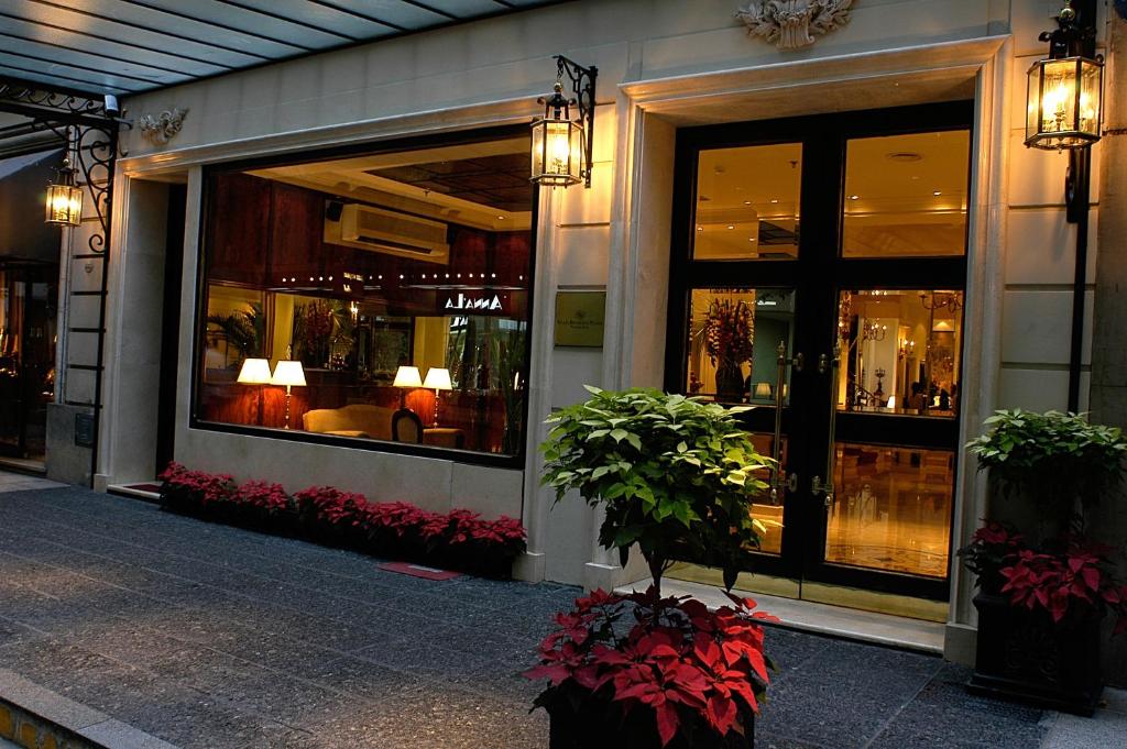 Melia Recoleta Plaza Hotel في بوينس آيرس: متجر أمام مبنى به نوافذ ونباتات