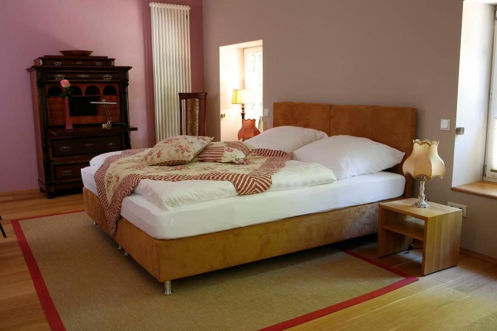 1 dormitorio con 1 cama grande con marco de madera en Haus Keppelborg: ZI Antonia mit Kirchplatzblick, en Heek
