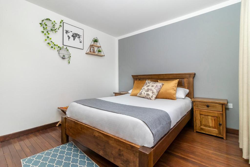 um quarto com uma cama e uma cabeceira em madeira em Corazon del Molino Corferias Bogota- Embajada Americana em Bogotá