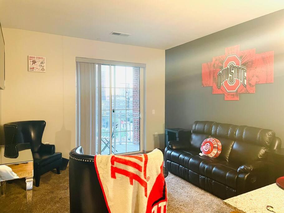 a living room with a leather couch and a window at King Size with OSU Theme! in Columbus