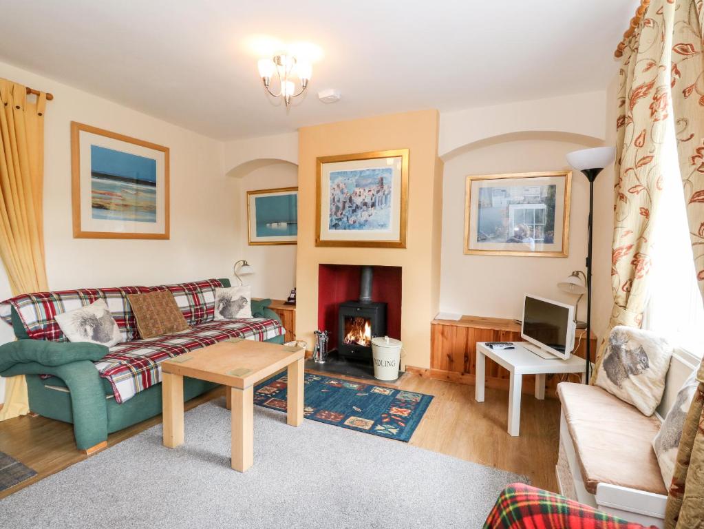 a living room with a couch and a fireplace at Crinan Canal Cottage in Lochgilphead