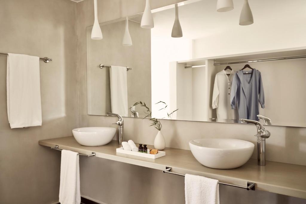 a bathroom with two sinks and a mirror at Yria Island Boutique Hotel & Spa in Parasporos