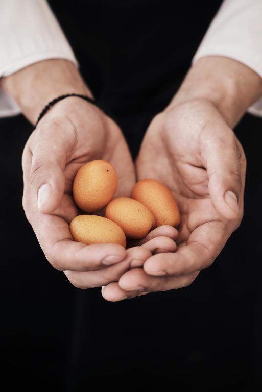 a man holding three brown eggs in his hands at Yria Island Boutique Hotel & Spa in Parasporos