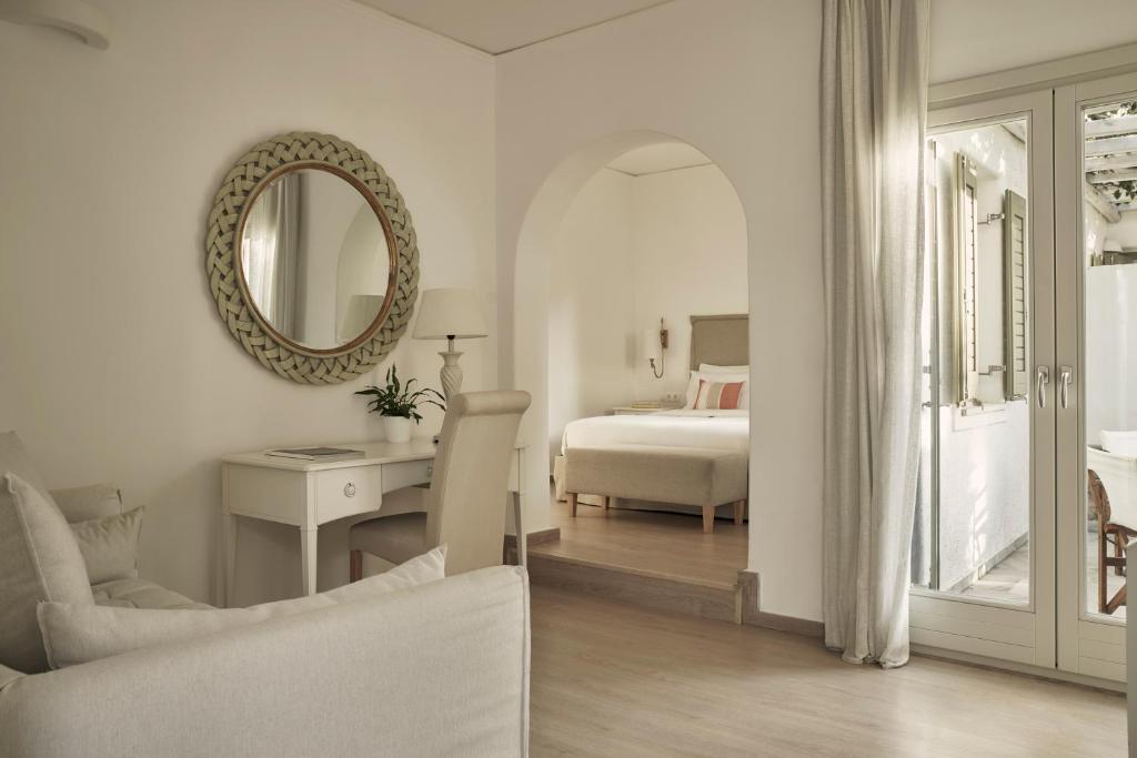 a white bedroom with a bed and a mirror at Yria Island Boutique Hotel & Spa in Parasporos