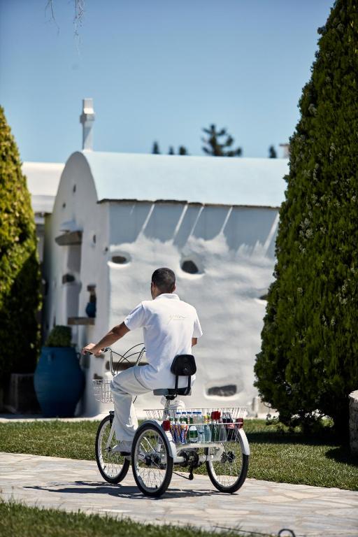 a man riding a bike in front of a church at Yria Island Boutique Hotel & Spa in Parasporos