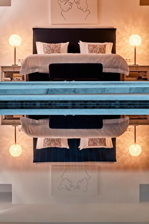 a bedroom with a large bed and a large blue bedvisorvisor at Yria Island Boutique Hotel & Spa in Parasporos