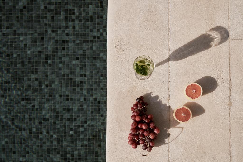 a bunch of grapes on the floor next to a glass at Yria Island Boutique Hotel & Spa in Parasporos