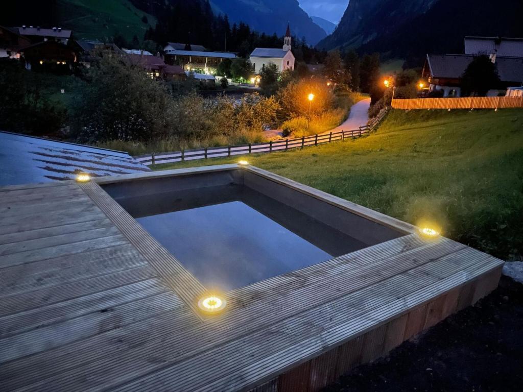a swimming pool with lights on a deck at night at Lovely Holiday Home in Mayrhofen with Garden and Whirlpool in Mayrhofen