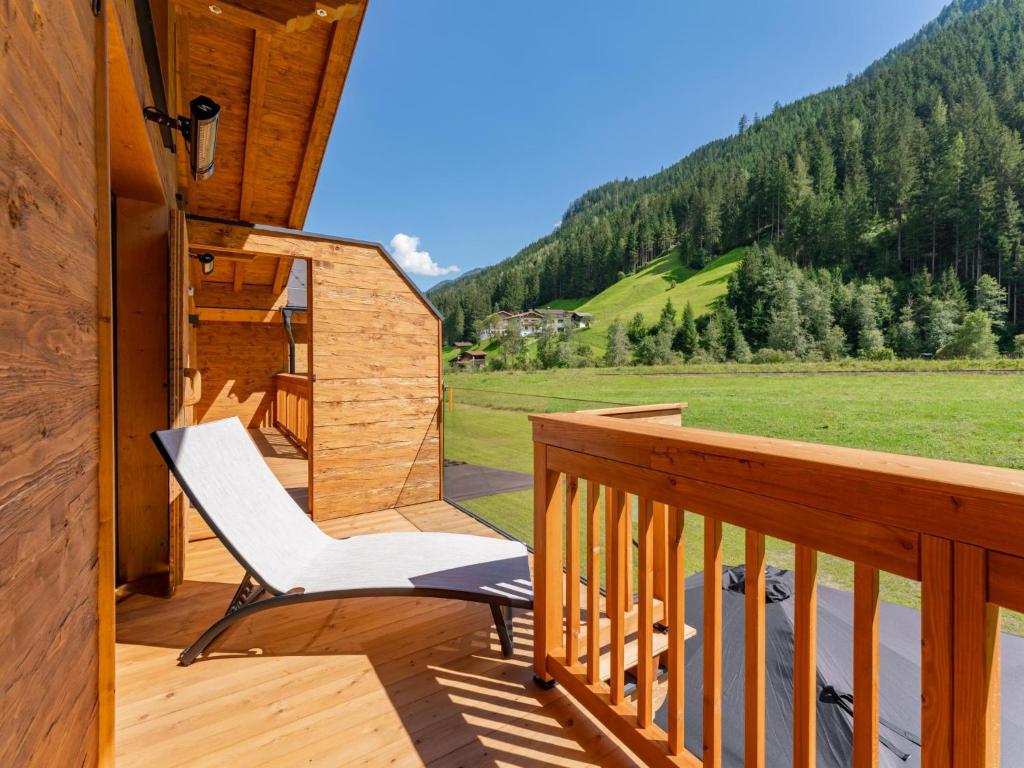 un fauteuil à bascule sur une terrasse avec vue sur la montagne dans l'établissement Pinzgau Lodge 1A 1B, à Wald im Pinzgau