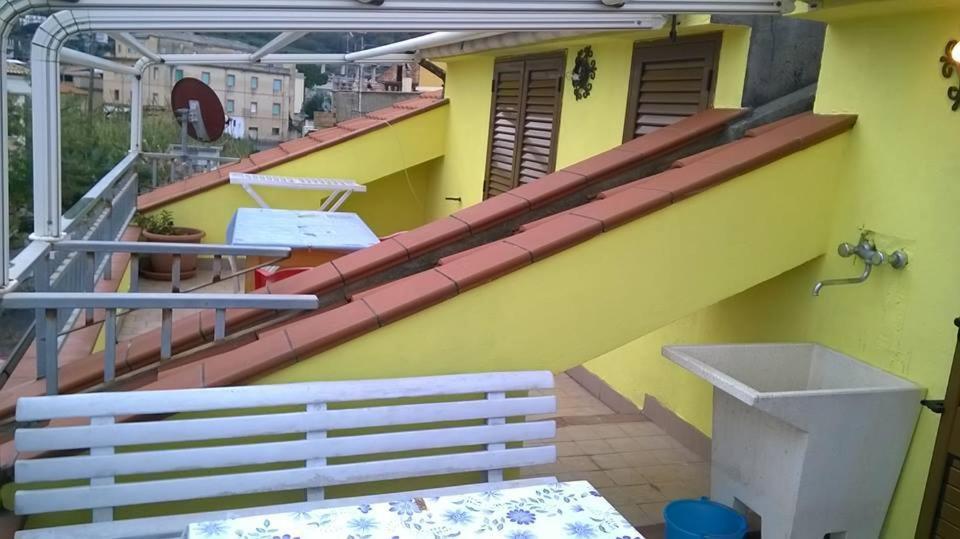 a balcony with a white bench and a yellow building at Bed and Breakfast Vibo Mare in Vibo Valentia Marina