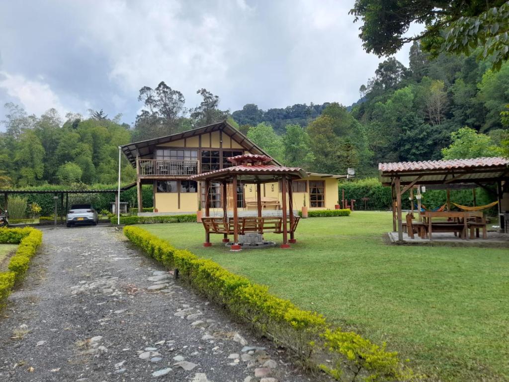 una casa con un gran patio con un edificio en Casa Campo Valle De Cocora en Salento