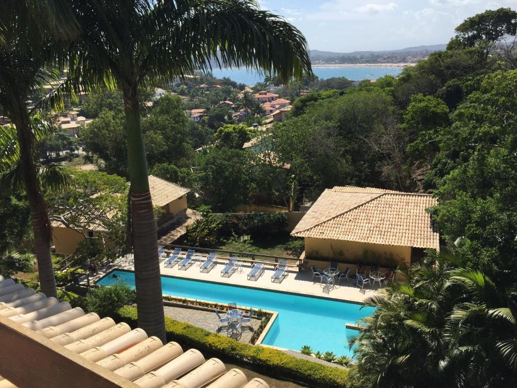 een uitzicht op het zwembad in een resort met palmbomen bij Praia da Ferradurinha Guest House in Búzios