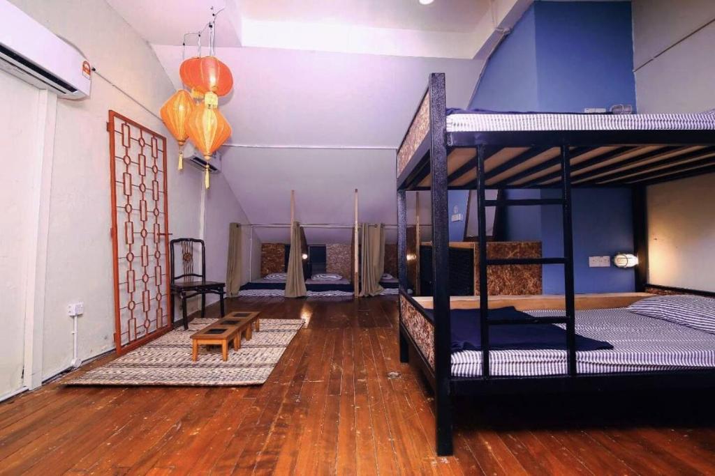 a room with two bunk beds and a wooden floor at 24 Seven B&B Mamasan in Kuching