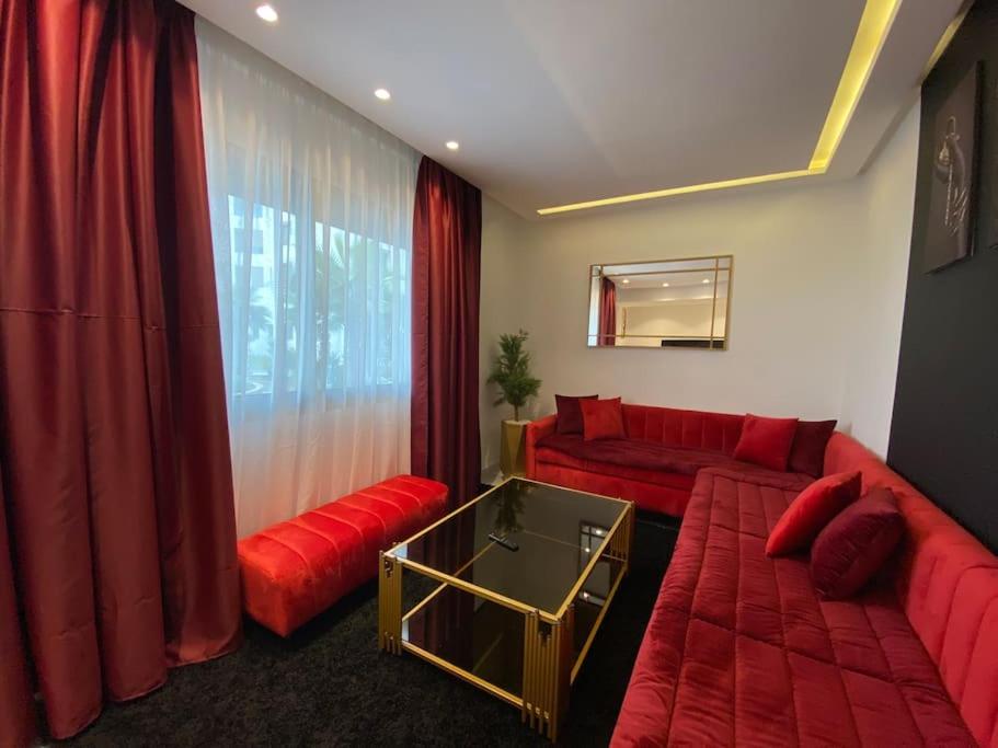 un soggiorno con mobili rossi e un divano rosso di Corniche Casablanca - Red’s Neuf a Casablanca