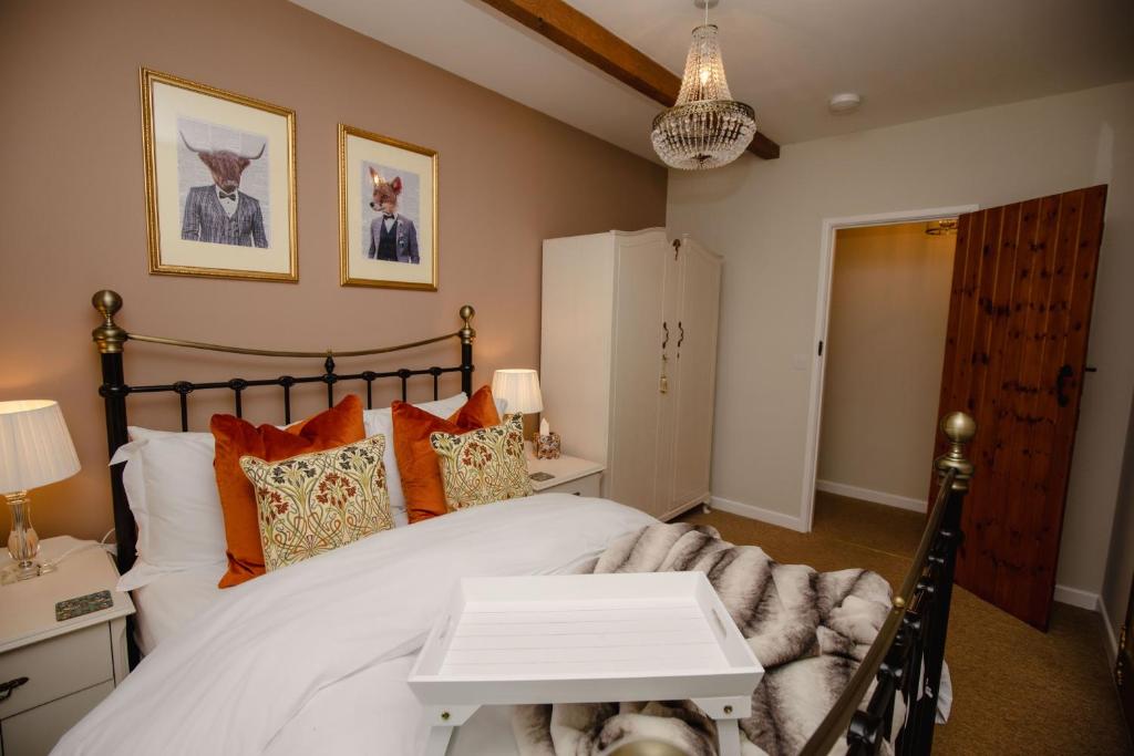1 dormitorio con 1 cama blanca grande con almohadas de color naranja en Orchard Cottage - Rudge Farm Cottages en Bridport