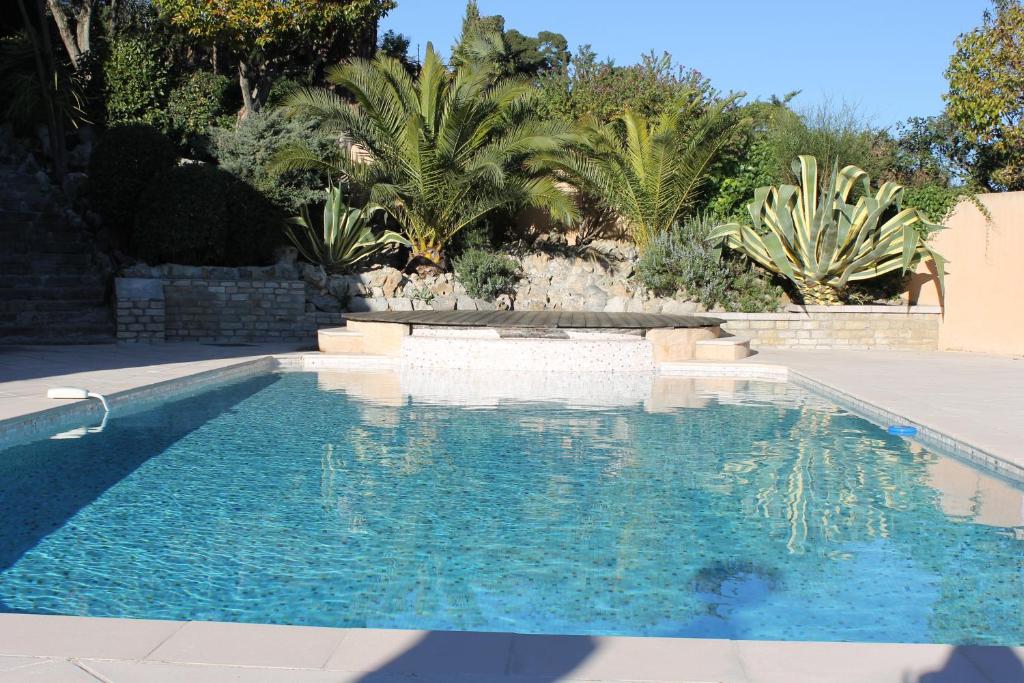 a swimming pool in a yard with palm trees at La Caladina in Mougins