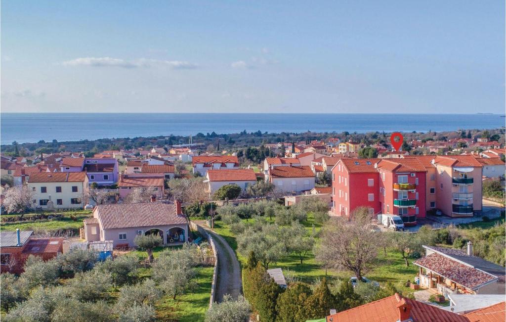 a small town with houses and the ocean in the background at Amazing Apartment In Peroj With 2 Bedrooms And Wifi in Peroj