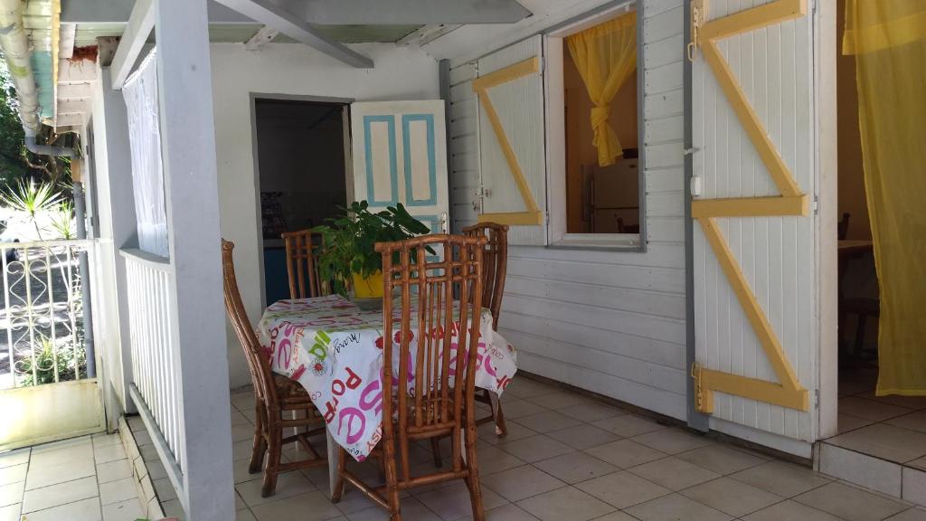 einen Tisch und Stühle auf der Veranda eines Hauses in der Unterkunft La Creoline 01 in Pointe-Noire