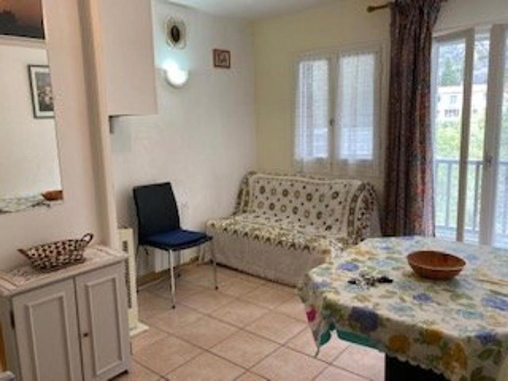 un salon avec un canapé et une table dans l'établissement Appartement F2 Confortable à Amélie-les-Bains – Balcon, Parking, Proche Thermes, Animaux Bienvenus - FR-1-703-15, à Amélie-les-Bains-Palalda