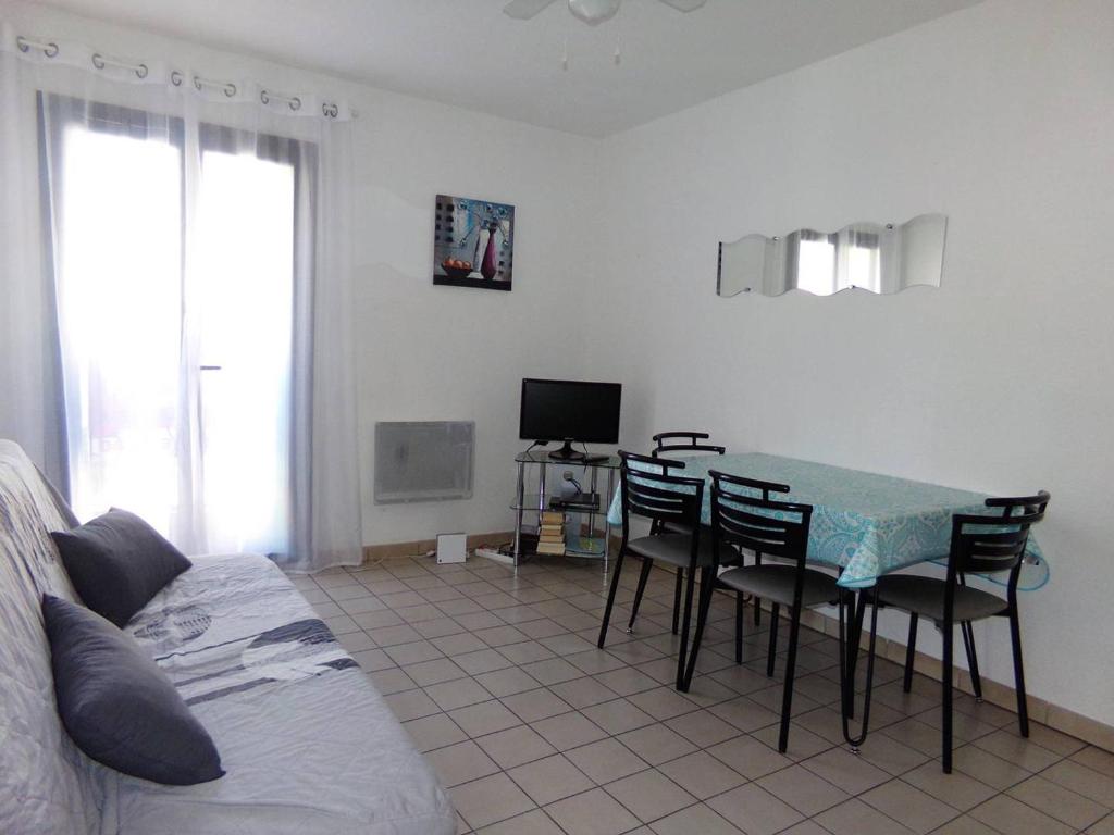 sala de estar con mesa, sillas y TV en Appartement Amélie-les-Bains-Palalda, 2 pièces, 2 personnes - FR-1-703-1, en Amélie-les-Bains-Palalda