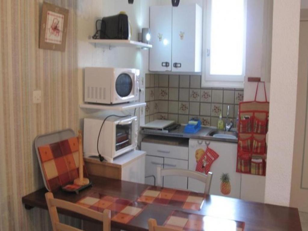 une petite cuisine avec une table et un four micro-ondes dans l'établissement Studio Amélie-les-Bains-Palalda, 1 pièce, 2 personnes - FR-1-703-33, à Amélie-les-Bains-Palalda