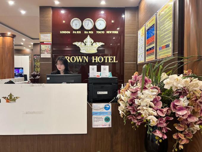 a woman sitting at a desk in a hotel lobby at Khách sạn Crown - Gần đại học Nông Lâm TN in Thái Nguyên