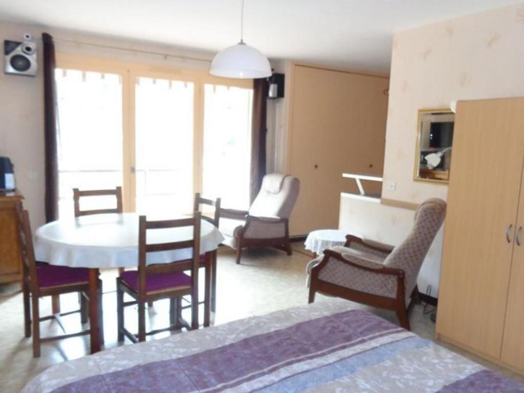 une chambre avec un lit, une table et des chaises dans l'établissement Studio confortable avec balcon, proche des Thermes et centre-ville, idéal pour 2 personnes avec WiFi - FR-1-703-90, à Amélie-les-Bains-Palalda