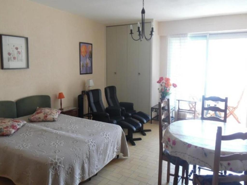 une chambre avec un lit, une table et des chaises dans l'établissement Studio confortable avec loggia et garage, proche centre-ville et cures, animaux bienvenus - FR-1-703-63, à Amélie-les-Bains-Palalda