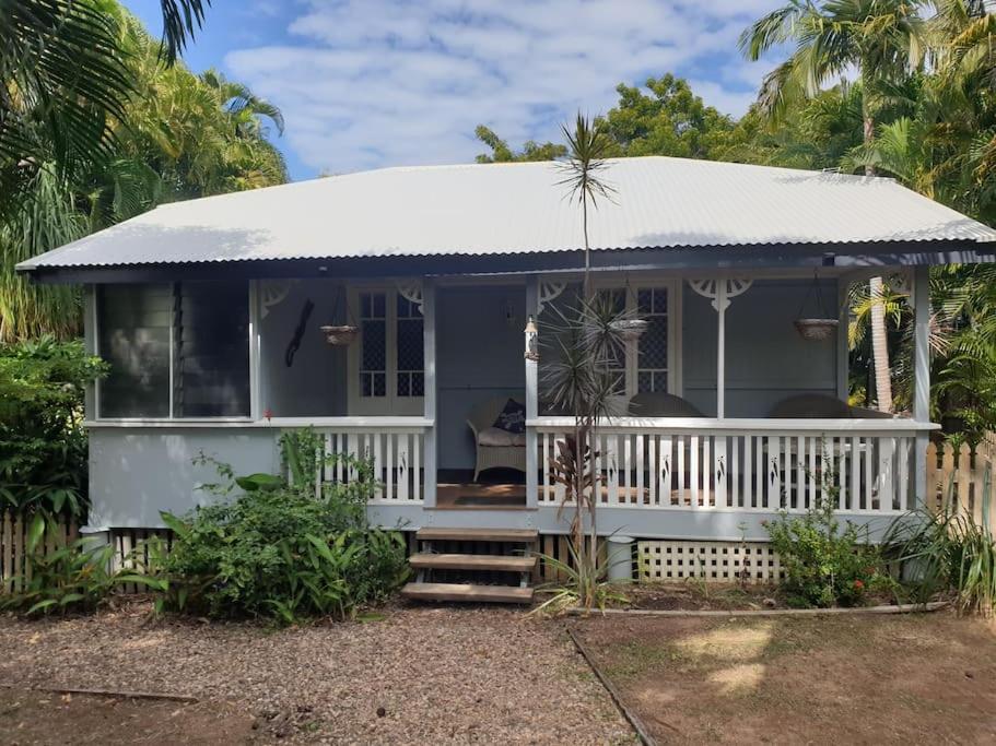 uma pequena casa azul com um alpendre branco em Turtle Cottage Magnetic Island em Picnic Bay