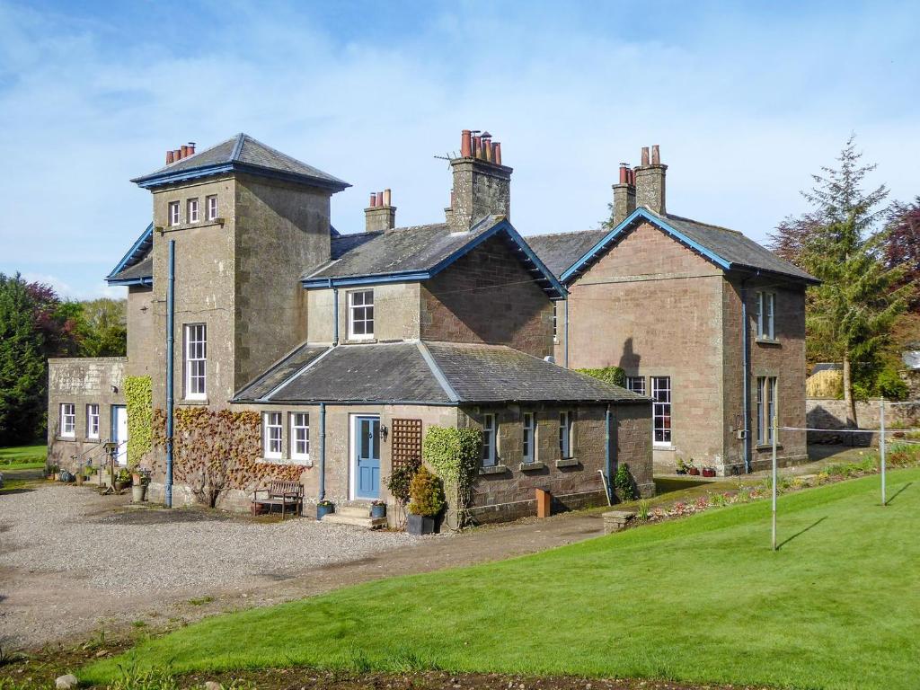 an old brick house with a grass yard in front of it at Craigellie in Alyth