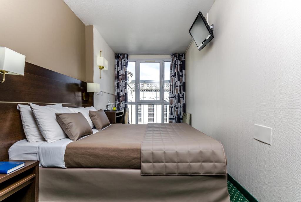 Postel nebo postele na pokoji v ubytování Hôtel Croix des Bretons - Lourdes Pyrénées