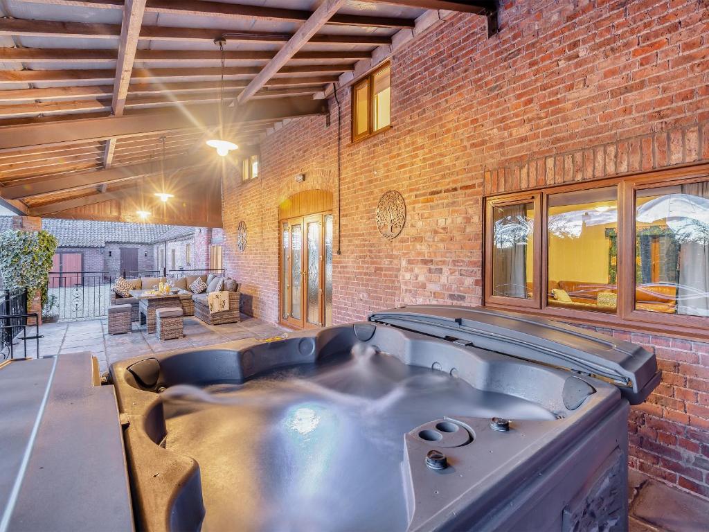a large room with a pool in a brick building at Barn House in Friskney