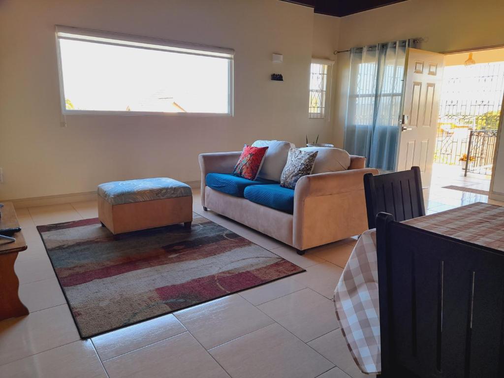 uma sala de estar com um sofá e uma cadeira em Ultimate Chill Montego Bay em Montego Bay