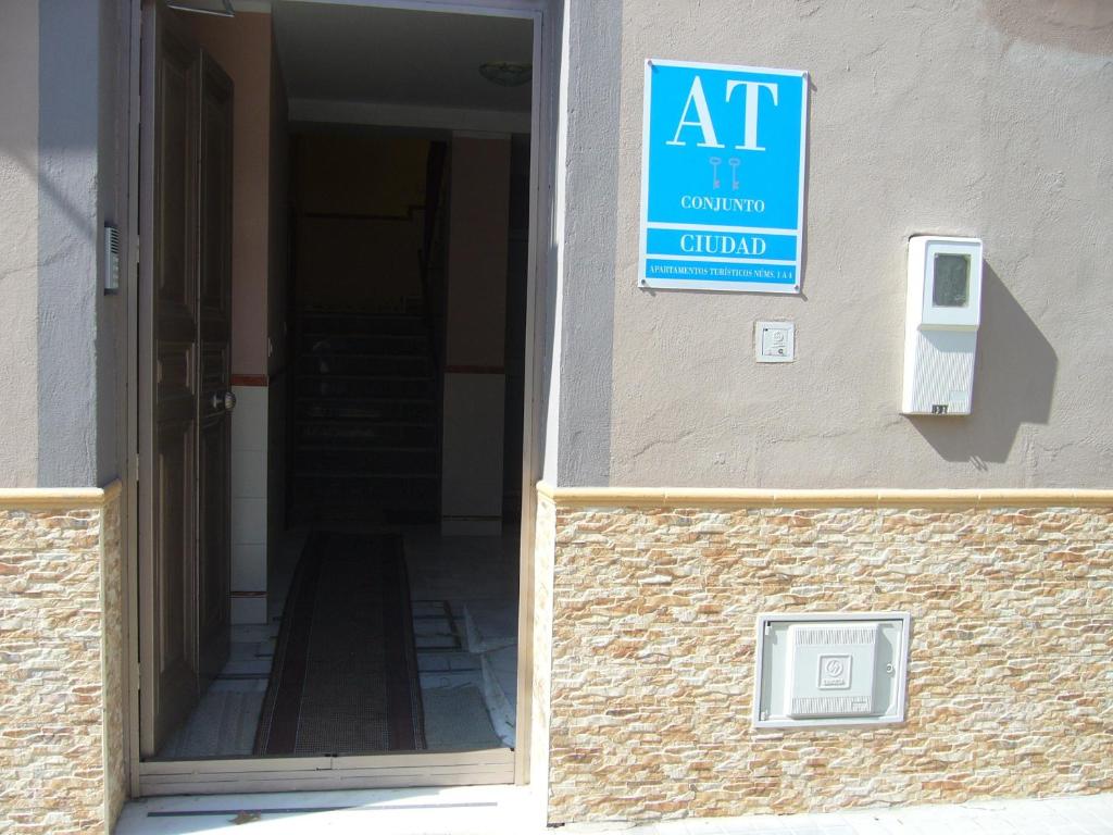 une entrée à un bâtiment avec un panneau sur le côté dans l'établissement Apartamentos Alamare, à Séville