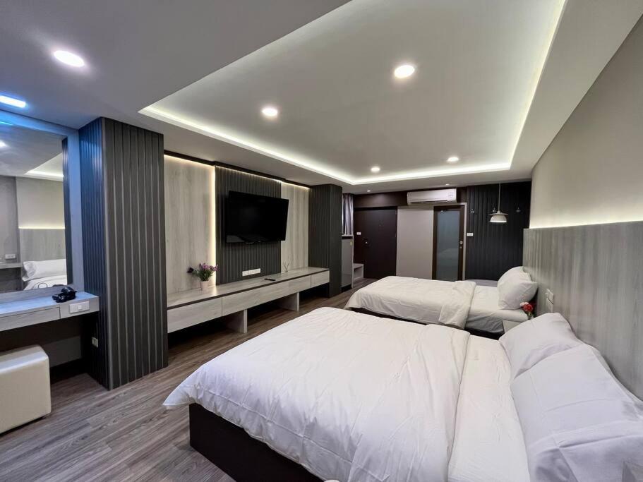 Una habitación de hotel con dos camas y un televisor. en DiscoveryHome at Pratunam market, en Bangkok