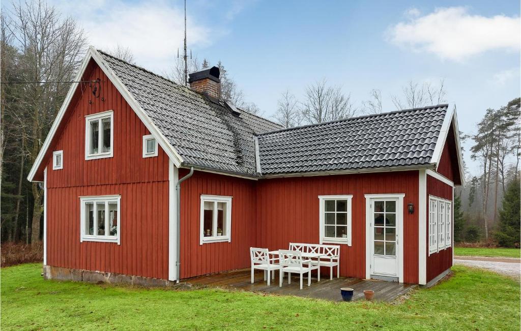 un granero rojo con una mesa y sillas. en 5 Bedroom Pet Friendly Home In Strmsnsbruk, en Strömsnäsbruk