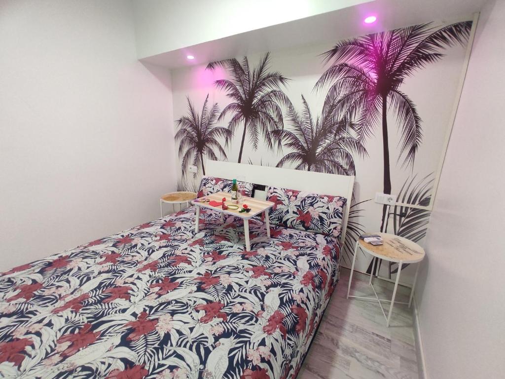 a bedroom with a bed and palm trees on the wall at Apto con Hidromasaje sweet Charco by flamingo house in Arrecife