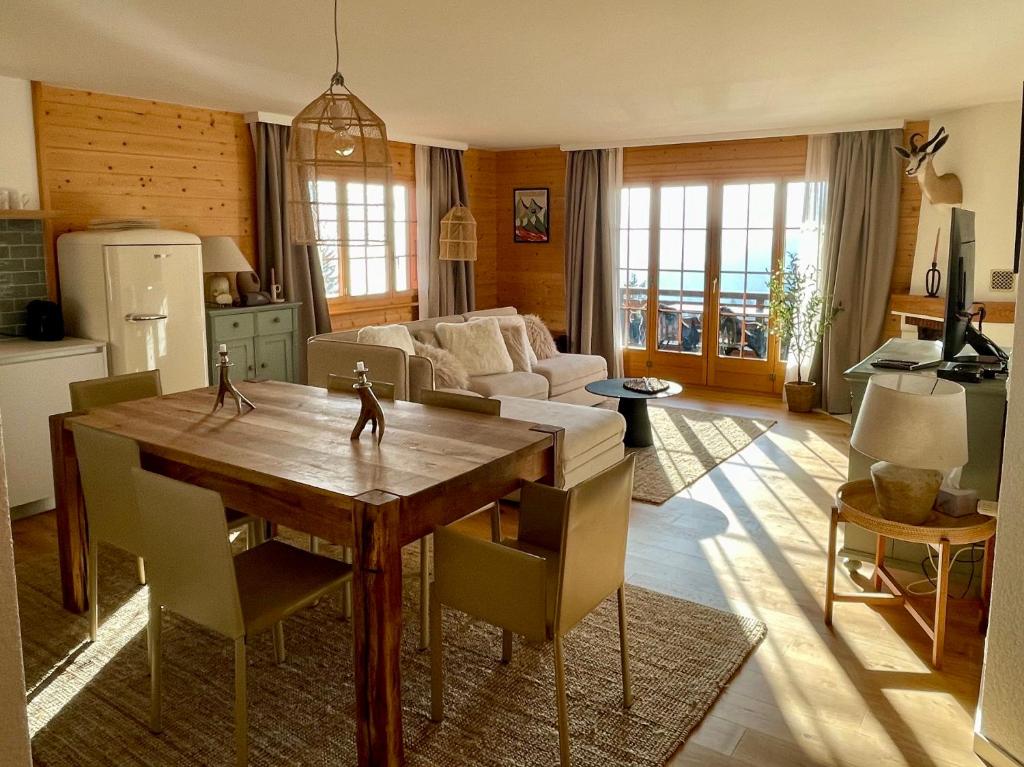 a living room with a table and a couch at Apartment with stunning view! Ski-in, ski-out in Villars-sur-Ollon
