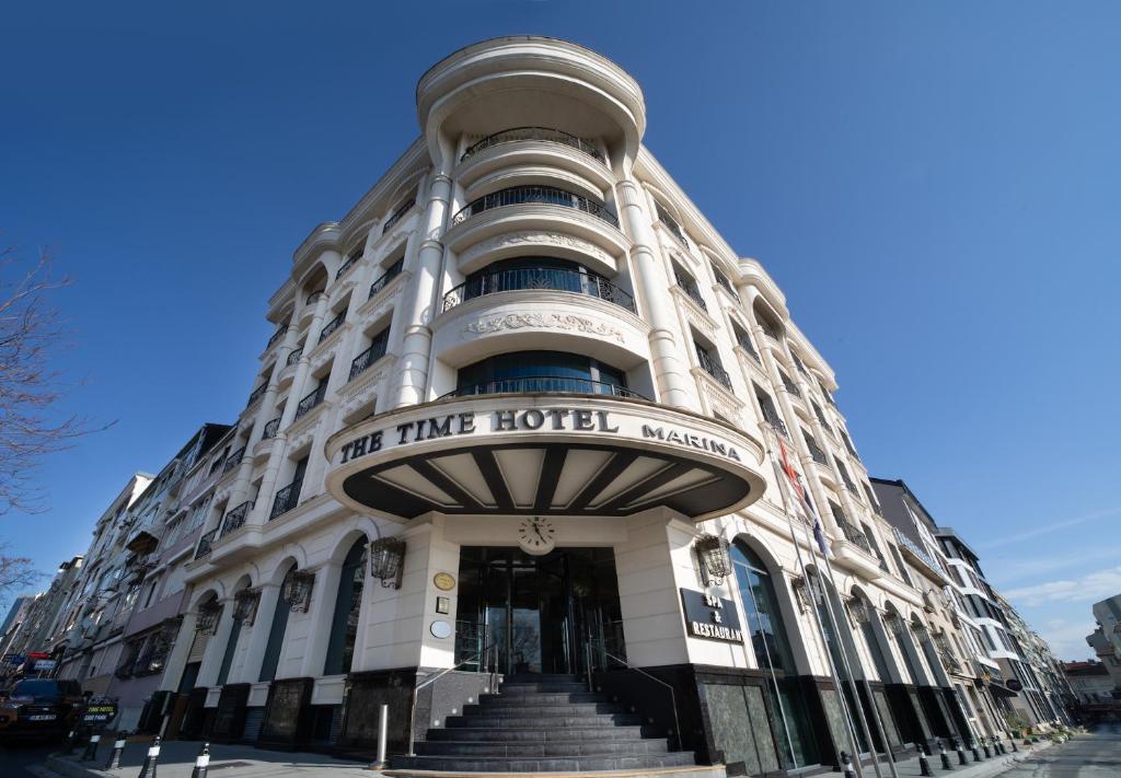 ein großes weißes Gebäude mit einer Treppe davor in der Unterkunft The Time Hotel Marina in Istanbul