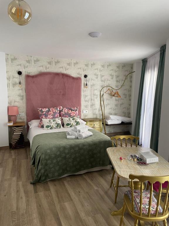 1 dormitorio con 1 cama y 1 mesa con sillas en Ateneo Cuenca en Cuenca