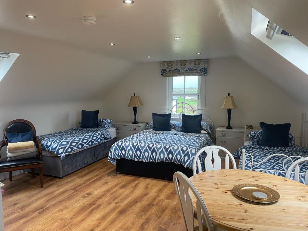 ein Schlafzimmer mit 2 Betten und einem Tisch mit einem Tisch in der Unterkunft Drum Manor Apartment Hillsborough BT26 6PU in Hillsborough